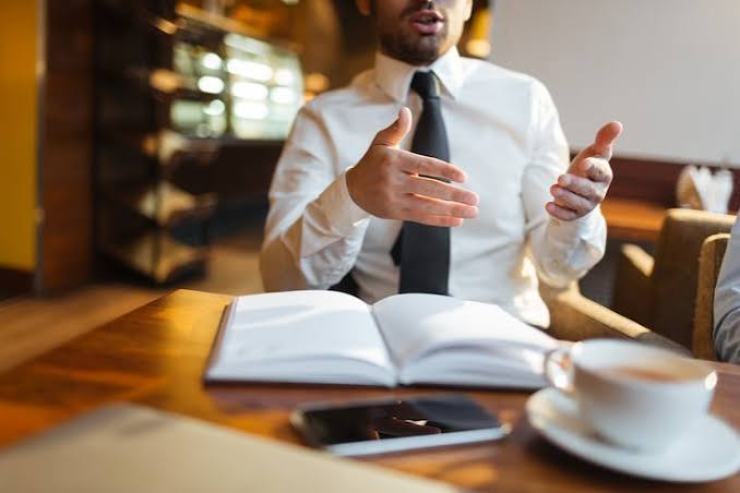 man with bible having coffee with another person